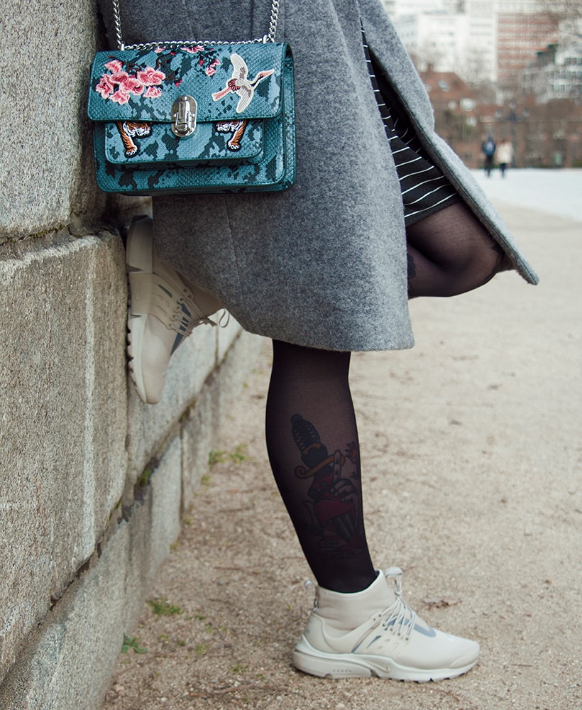 Matilda Anton leaning against a wall wearing Nike Air Presto Utility
