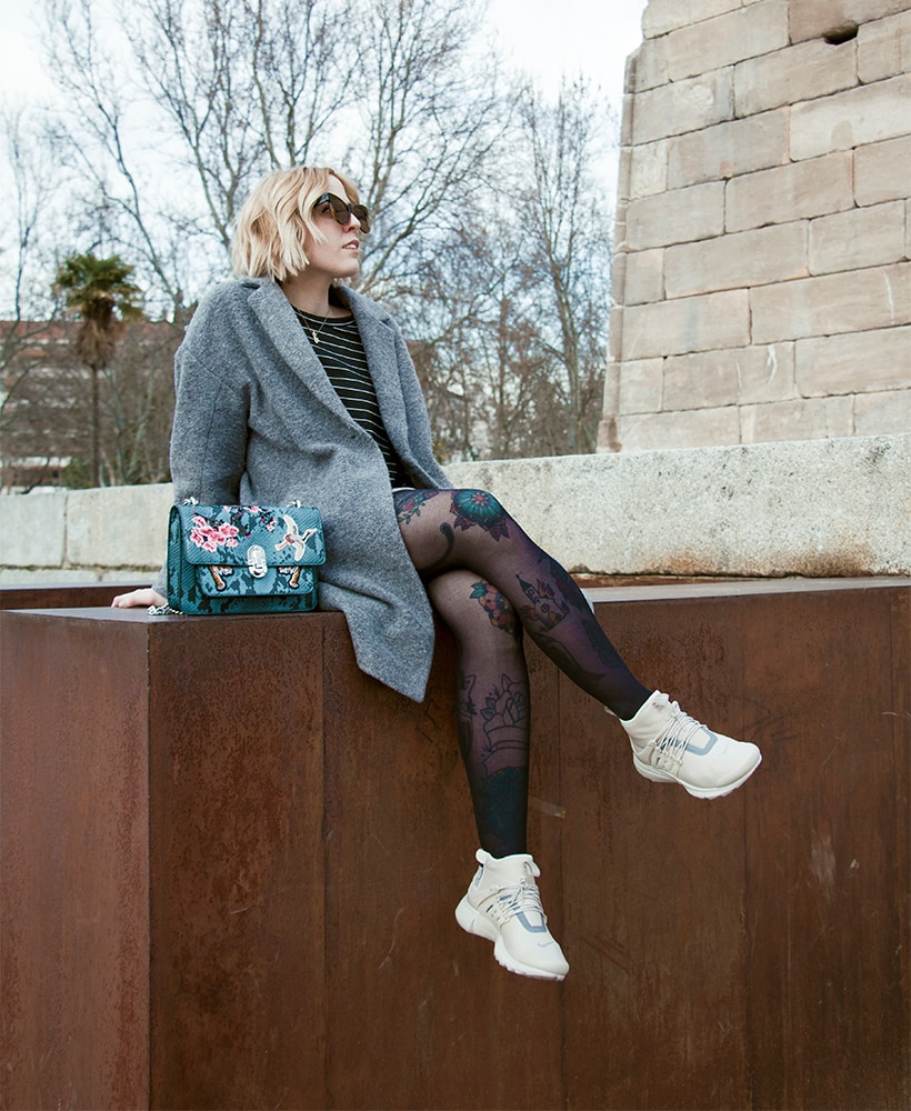 Matilda Anton sat on a wall wearing Nike Air Presto Utility