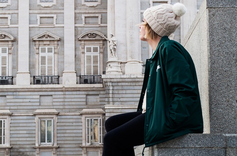 Matilda Anton sat on wall wearing Carhartt coach jacket